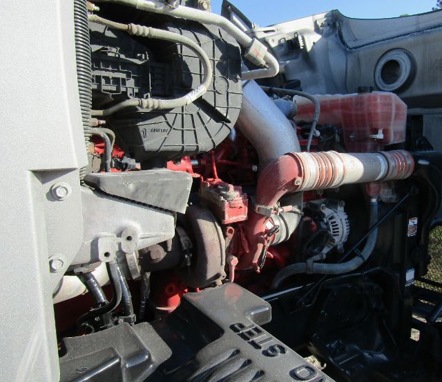Kenworth T680 engine bay showing turbocharger, hoses, and coolant reservoir.