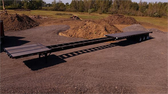 Flatbed trailer showing extendable all-steel structure with rear and front deck sections and a long, narrow middle frame; no visible text labels on the trailer.
