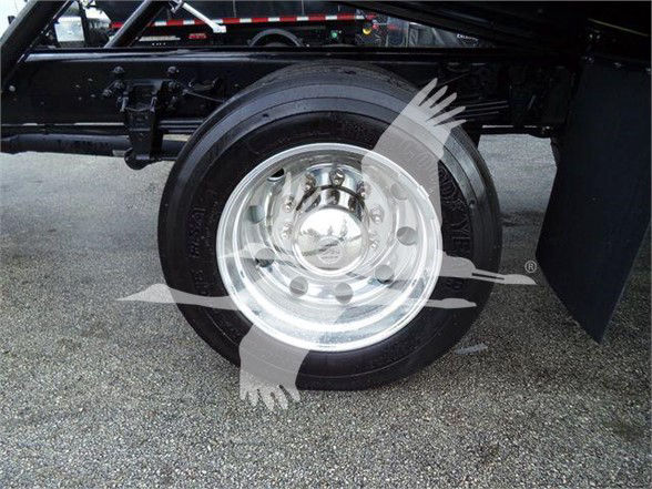 Ford F-750 SD chassis showing wheel and tire on trailer-type truck, with chrome wheel and undercarriage components visible.