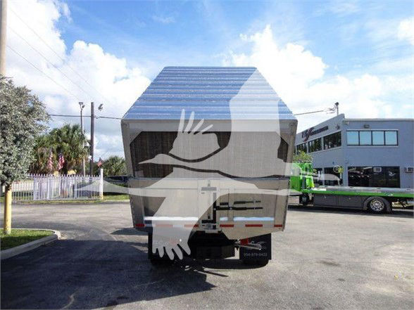 Ford F-550 dump truck rear view with aluminum dump bed and chassi, label area visible, truck in dealership lot.