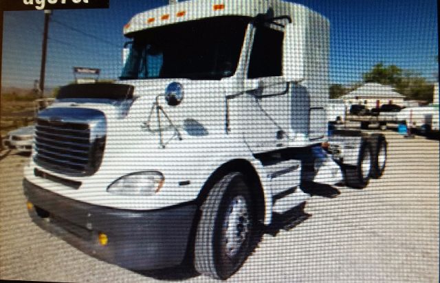 Truck in a lot showing a white Freightliner Columbia 112 cab with black grille and chrome mirrors.