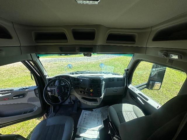 Peterbilt 579 truck interior view from passenger seat showing steering wheel, dashboard, and front windows.