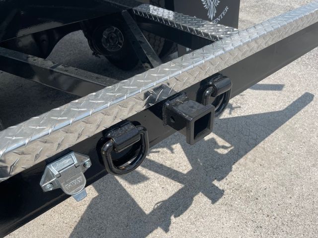 Freightliner M2 rear bumper area showing two black square hitch receivers and a small latching hitch, plus a silver latch with stamped text.