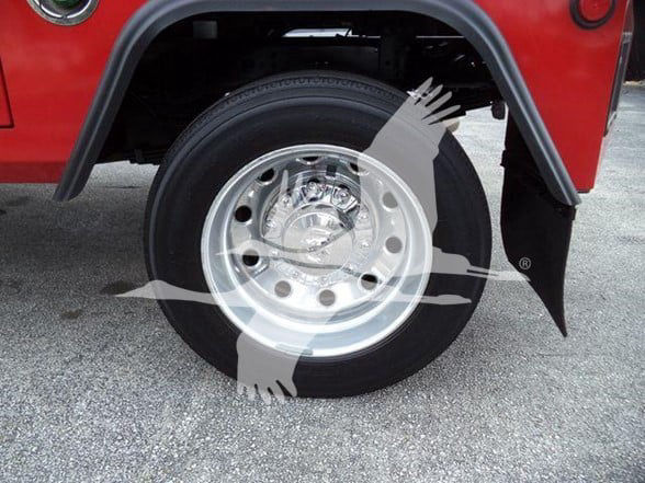 Wheel and fender of a red Ram 4500 with chrome steel wheel and black tire, partial front fender view.
