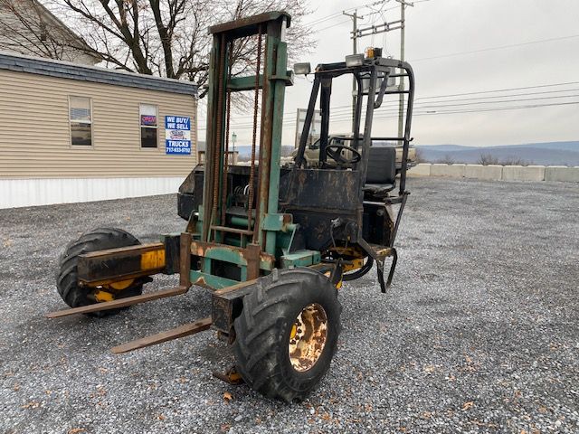 Kesmac F5000 forklift with green frame, black seat, large rear tires, and extended fork arms. VIN K5000F 145 visible on listing. Stock number 12724. Used equipment in outdoor lot.