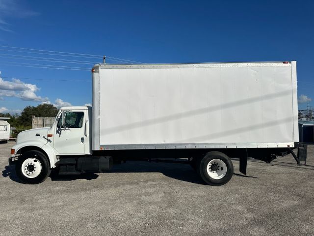 Box truck side view showing 1997 International 4700 with white cab and large box cargo area, VIN 1HTSCAAM4VH463682, category box, type trucks, used.