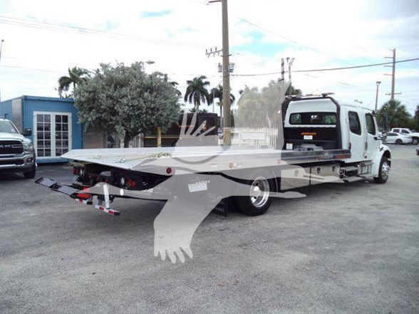 Freightliner Business Class M2 106 tow truck flatbed rear view showing platform and wheel lift.