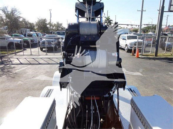 Freightliner M2 106 truck with heavy-duty tow equipment and coiled hoses visible in the bed area.