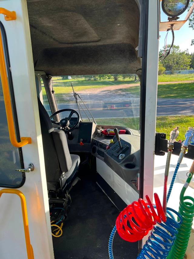 Cab interior of a Kalmar Ottawa T2 4x2 yard truck showing steering wheel, dashboard, and control levers from entry door side.