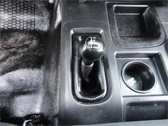 Shift knob and center console of a 2012 Ram 3500 SLT showing manual 4x4 shifter with position indicators and cup holder.