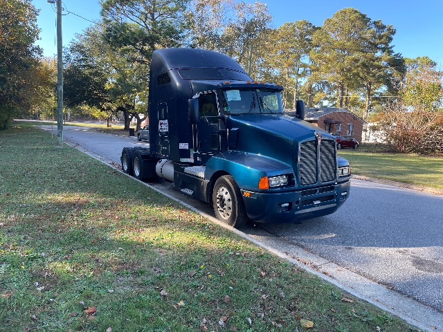 Blue 2007 Kenworth T600 conventional sleeper semi-truck parked on street, with dual rear axles, large aerodynamic sleeper cab, and chrome front grille.