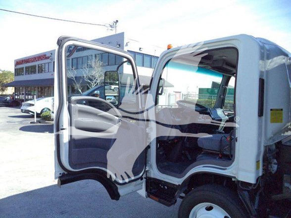 Isuzu NRR cab with open driver door showing interior and steering wheel.