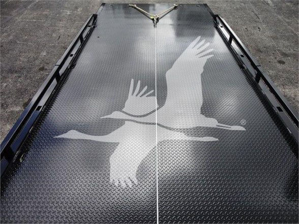 Diamond plate truck bed with gull artwork and rails on sides.