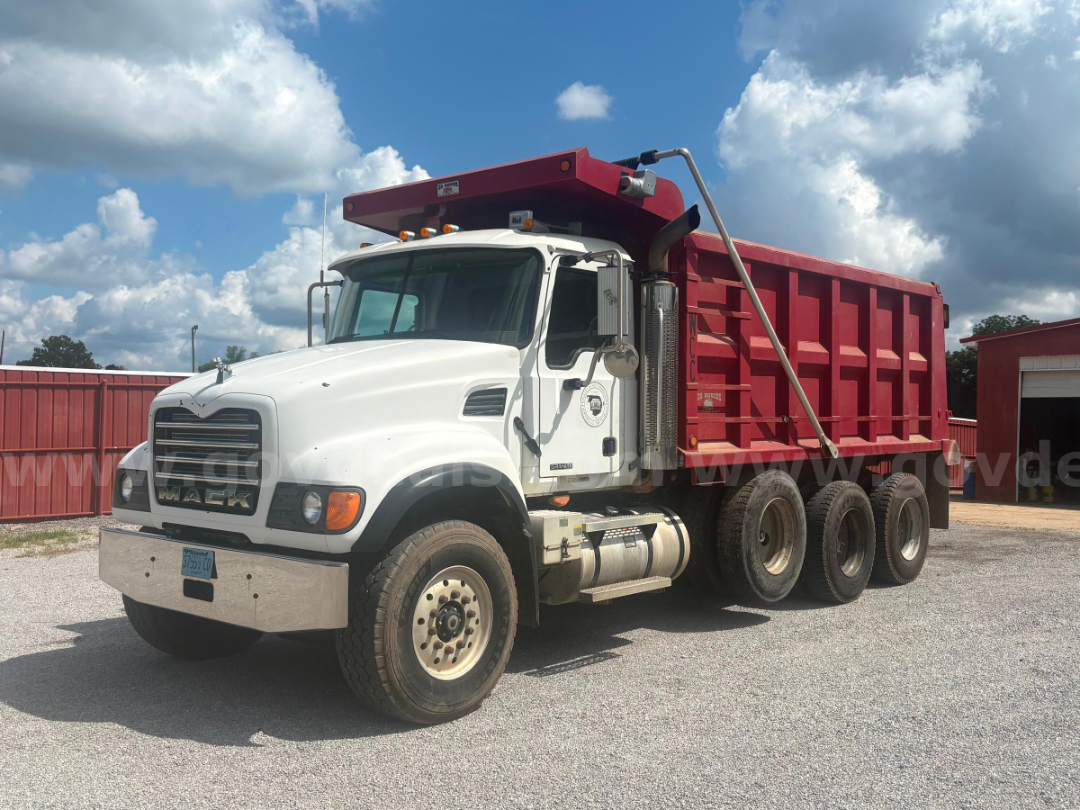 Dump truck cab and red dump body, 6x4 axle configuration, Mack CV713 with white cab and large chrome bumper.