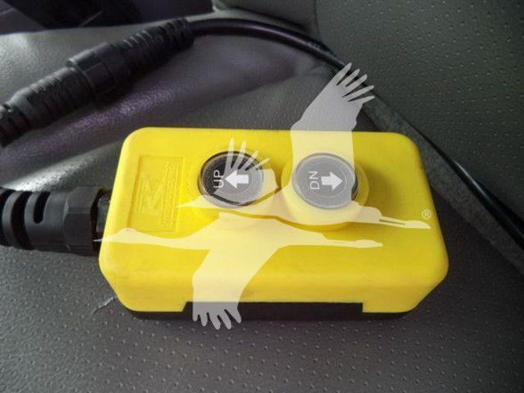 Yellow battery disconnect switch with up and down arrows installed in a Ford E-450 interior.