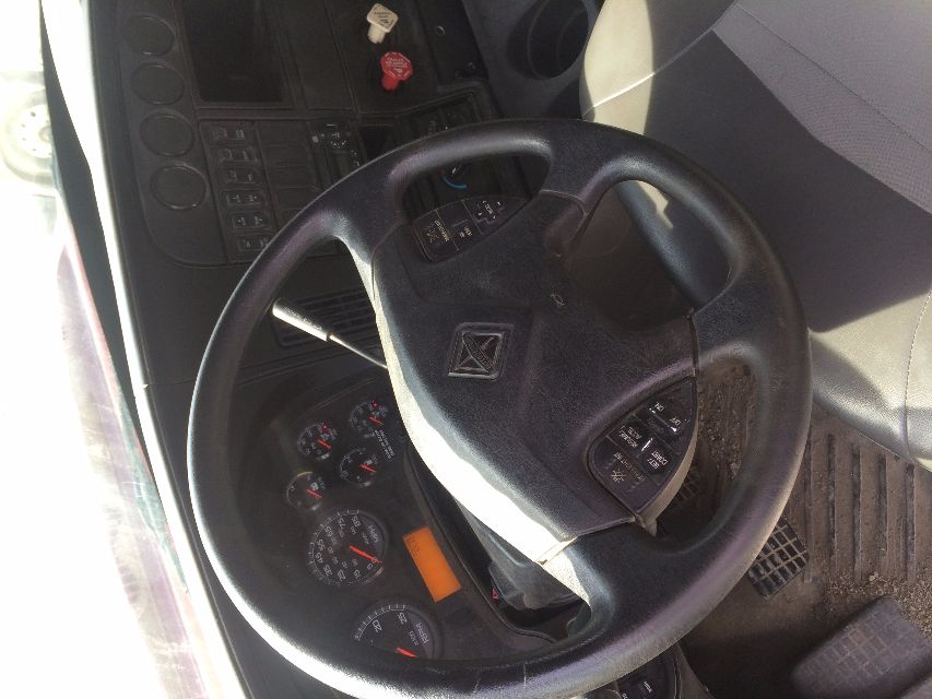 Interior of a 2011 International Prostar truck cab showing steering wheel, dashboard gauges, and control panels.