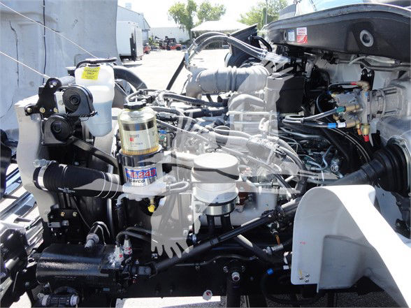 Truck engine bay showing multiple hydraulic lines, filters, and engine components in a 2022 Hino 268A tow truck.