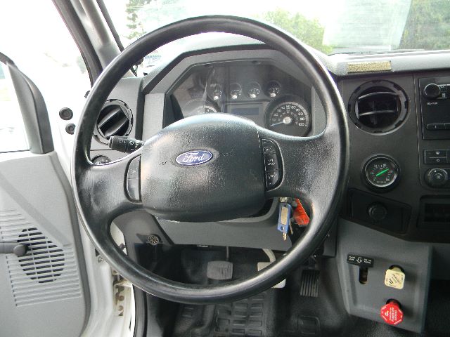 Ford steering wheel and dashboard inside Ford F-750 cab showing instrument cluster, ignition keys, and center console.