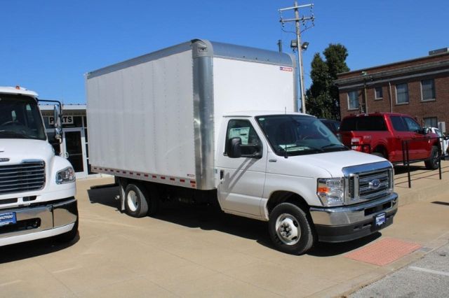 Ford E-450 box truck in a dealership lot, white cab with aluminum box, gray bumper and mirrors visible.
