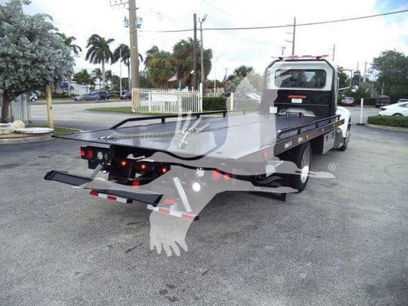 2019 Peterbilt 337 tow truck flatbed rear view showing dual rear lights and flatbed equipment.