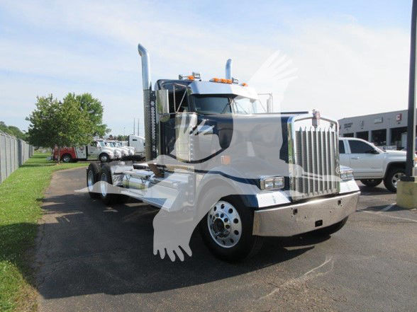 Kenworth W900L truck in a dealership lot with chrome grille, dual exhaust stacks, and large front bumper. visible side view shows cab and long wheelbase.