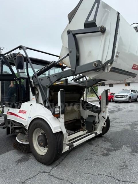 Elgin Pelican NP sweeper truck with elevated hopper lifting system; side shows Elgin branding and controls near the cab.