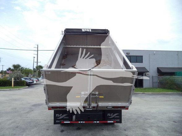 Rear view of a dump truck bed on a Isuzu NPR HD chassis, with TLC trailer logo on bumper area; no legible model text visible on tailgate.