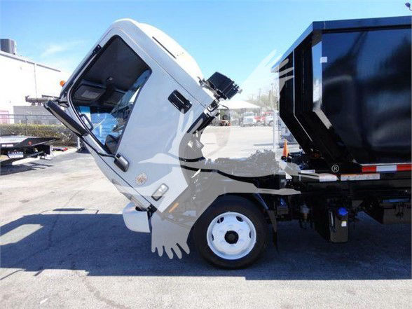 Isuzu NRR truck with cab tilted forward showing engine area and front wheel, gray cab, and dump bed visible.