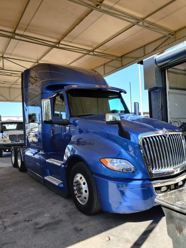 Blue 2020 International LT sleeper cab tractor truck with chrome grille and dual rear axles under a canopy.
