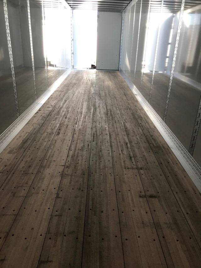 Interior of a Hyundai trailer with wooden floor and metal side walls; empty cargo space