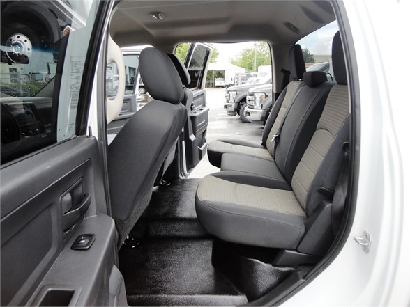 Interior of a 2012 Ram 3500 SLT crew cab showing front and rear seats, black and gray fabric upholstery, and door panel.