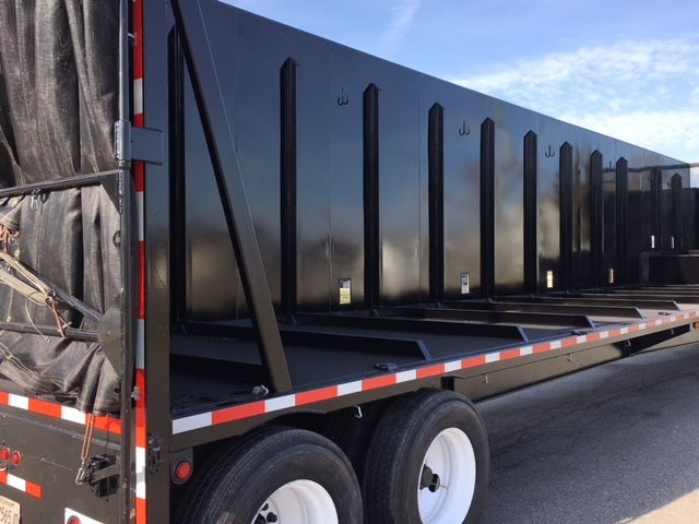 Great Dane single drop trailer side view showing black steel side walls, white wheels, and reflective red/white safety strip. No legible model numbers or fluid labels visible.