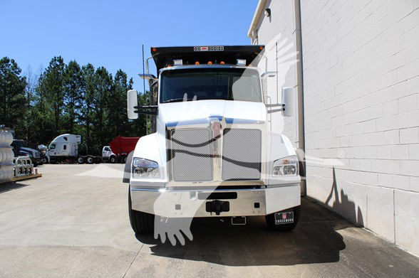 Kenworth T880 dump truck front view with chrome grille and mirrors, white cab, and light bar on top.