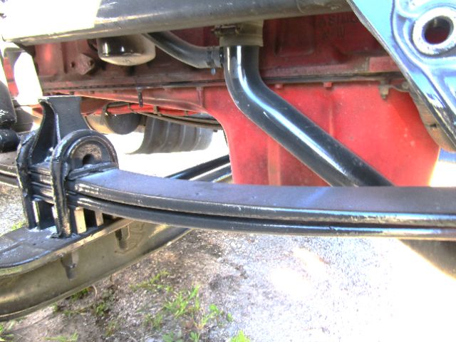 Kenworth T680 chassis showing suspension components and frame rails, with red painted area and blue hitch mount.