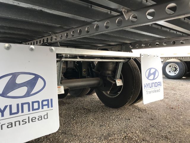 Underbelly of a Hyundai Translead trailer showing wheels and suspension with Hyundai Translead branding on mud flaps.