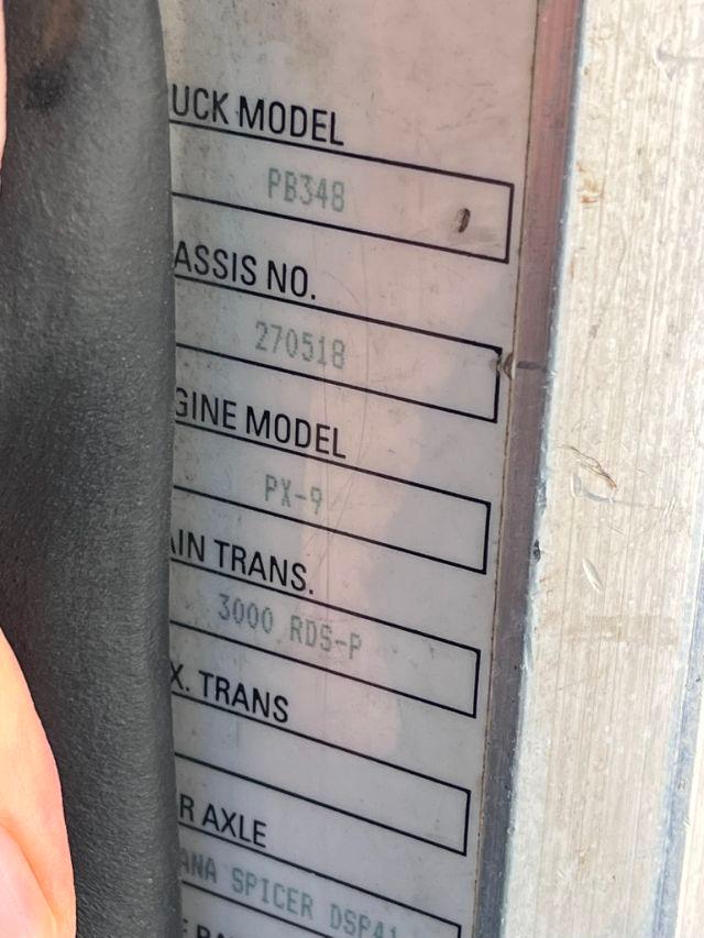 Truck model labels reading PB348, engine model PA-9, transmission 3000 RDS-P, chassis number 270518, etc. visible on a metal plate.