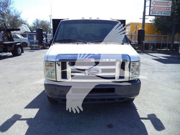 Front view of a white 2011 Ford E-450 flatbed truck with chrome grille and bumper.