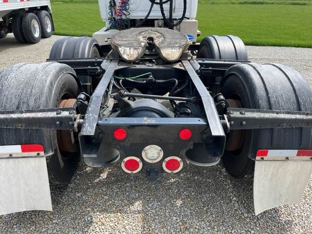 Freightliner Cascadia rear chassis showing fifth wheel, dual rear axles, air lines, and mud flaps.