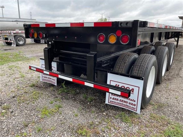 Flatbed trailer rear view showing dual-axle triple tire setup and rear frame with lights; Fontaine XCALIBUR extendable 53'-90' designation not visible; stock number 5A0653 EXT 5390 C present on listing tag.