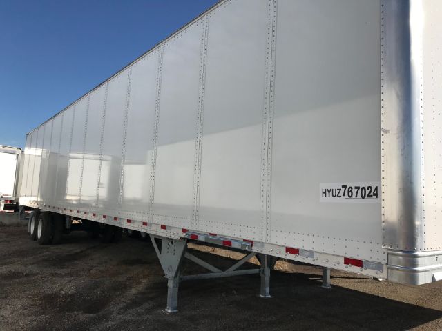 Side view of a long white Hyundai trailer with ribbed metal panels and hyuz67024 tag on the front side.