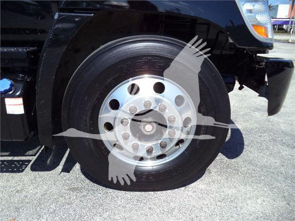 Truck front wheel showing polished aluminum rim and black tire, part of a reefer truck.