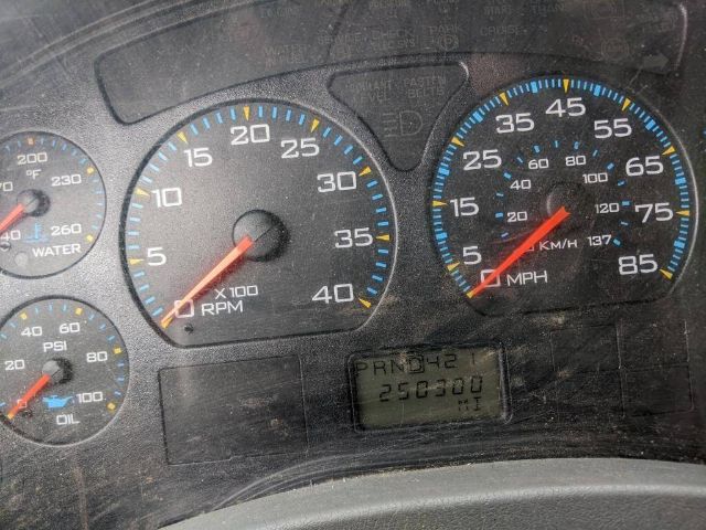 Dashboard gauges from a 2005 International 4300 showing tachometer, speedometer, and an odometer/gear display. Visible text includes PRND42 and 256300 miles.