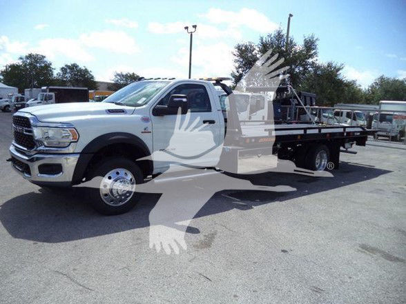 2024 Ram 5500 SLT tow truck side view with flatbed, white paint, dual rear wheels, and stock number J40687 visible.