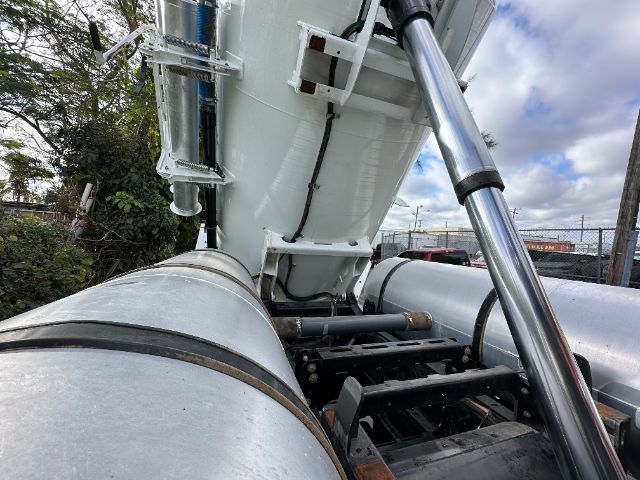Freightliner M2 vacuum truck components showing hydraulic strut, cylindrical tanks, and coupling pipes.