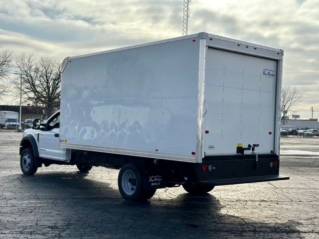 Front-left side view of a white 2022 Ford F-550 box truck. The box truck has a large white cargo box, black rear bumper step, and dual rear wheels.