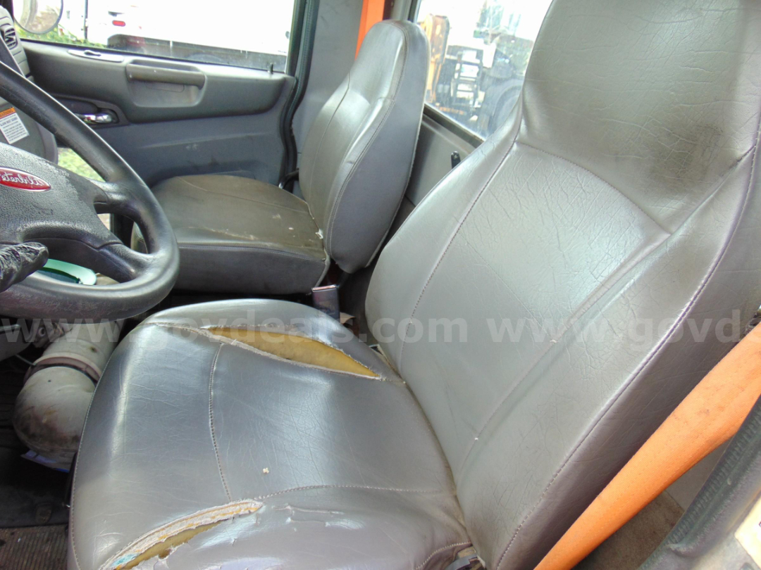Cab and Chassis truck interior showing driver seat and passenger seat with visible wear and tear on the leather upholstery.