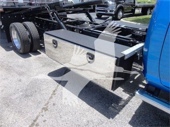 Ram 5500 chassis with storage box mounted behind cab, dual rear wheels visible, blue cab, utility truck configuration.