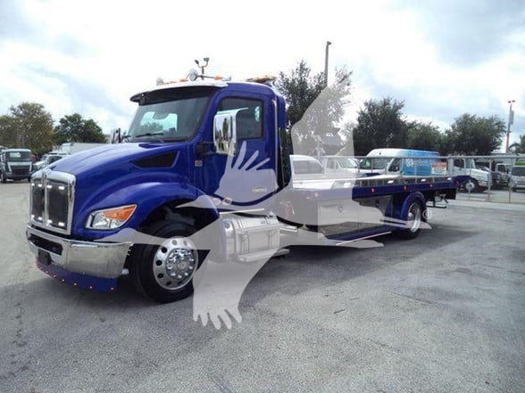 Kenworth T280 tow truck in blue with matching body panels and chrome front bumper, long flatbed visible behind cab.