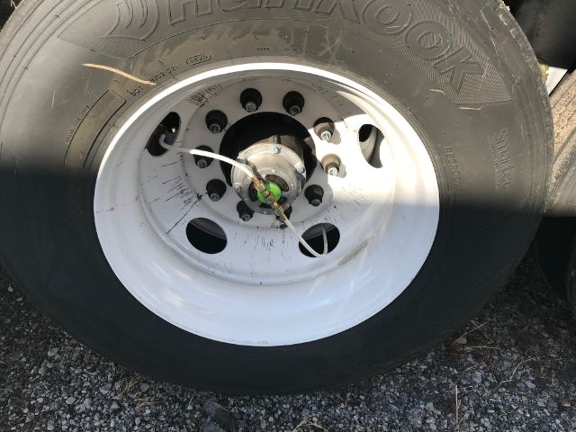Horizon Dunlop tire mounted on white steel rim with lug nuts; central hub with green valve core; tire sidewall shows 'DUNLOK' branding.