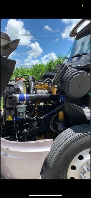 International Prostar engine bay showing hydraulic lines, filters, and front wheel with tire.